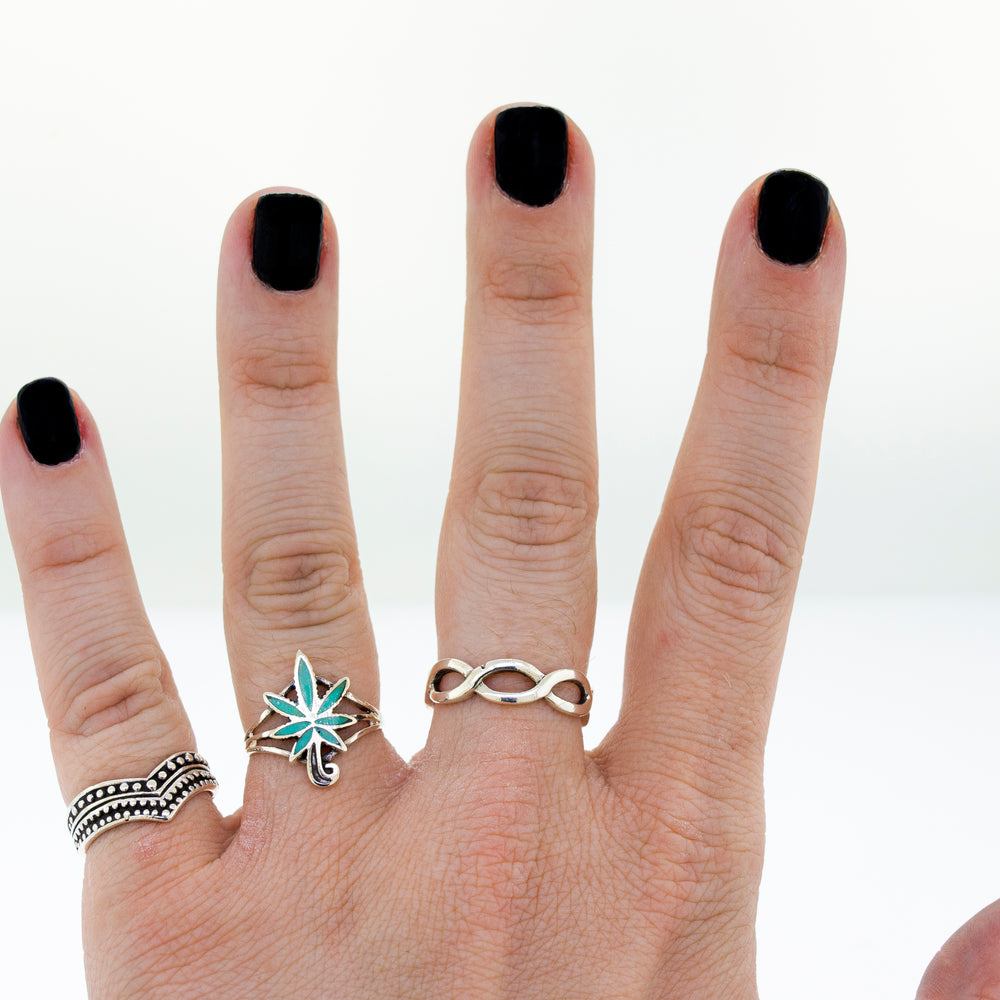 
                  
                    A woman's hand with an Inlay Stone Marijuana Leaf Ring on it.
                  
                