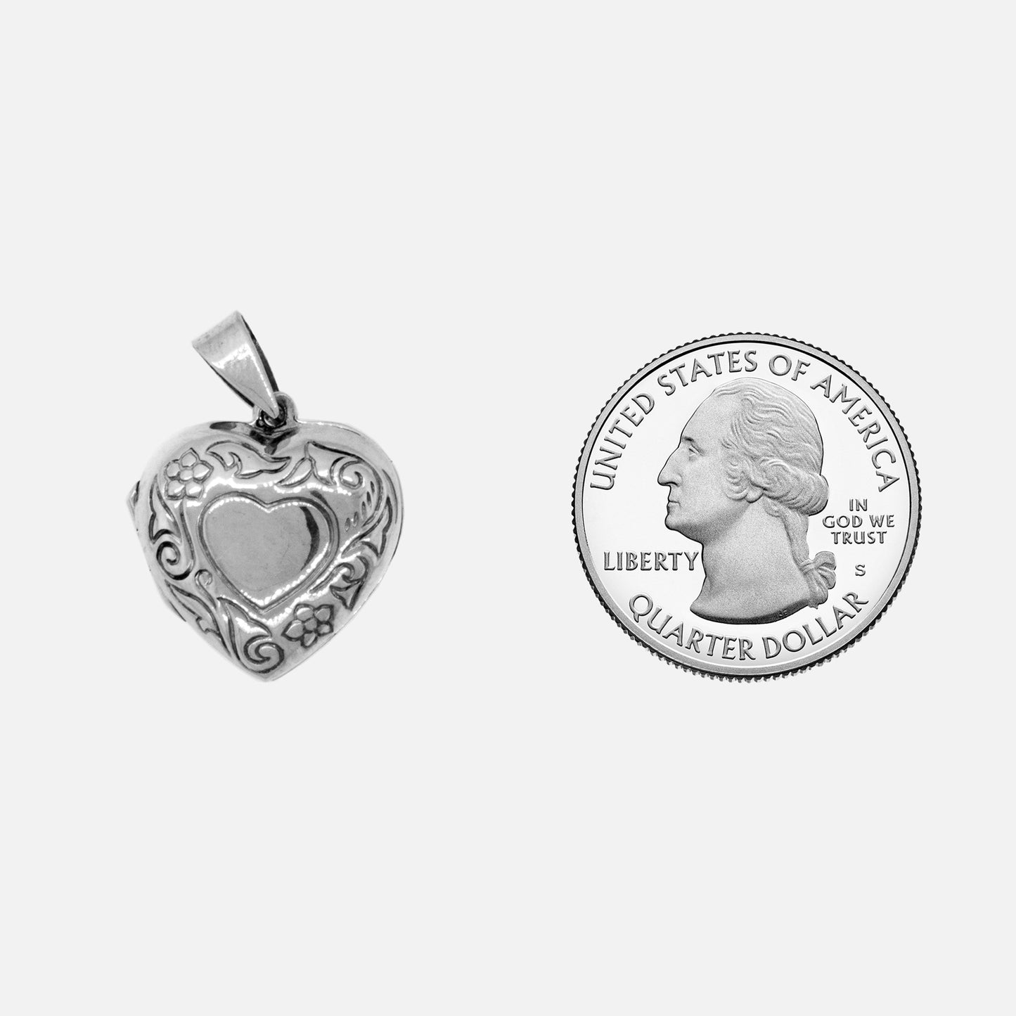 
                  
                    A Small Heart Shaped Locket with Flower crafted in sterling silver, alongside a quarter by Super Silver.
                  
                