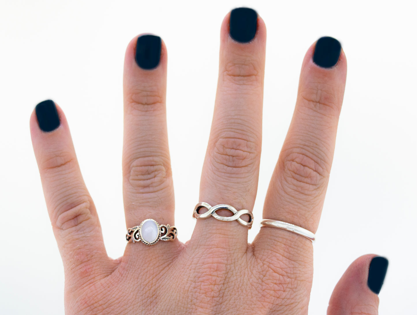 
                  
                    A woman's hand with an Oval Inlaid Ring with Swirls and Leaf Detailing.
                  
                