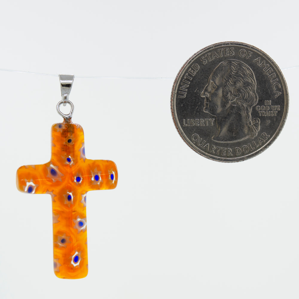 A Super Silver Cross Pendant with Flower Pattern adorned with a delicate flower pattern, placed next to a dime.