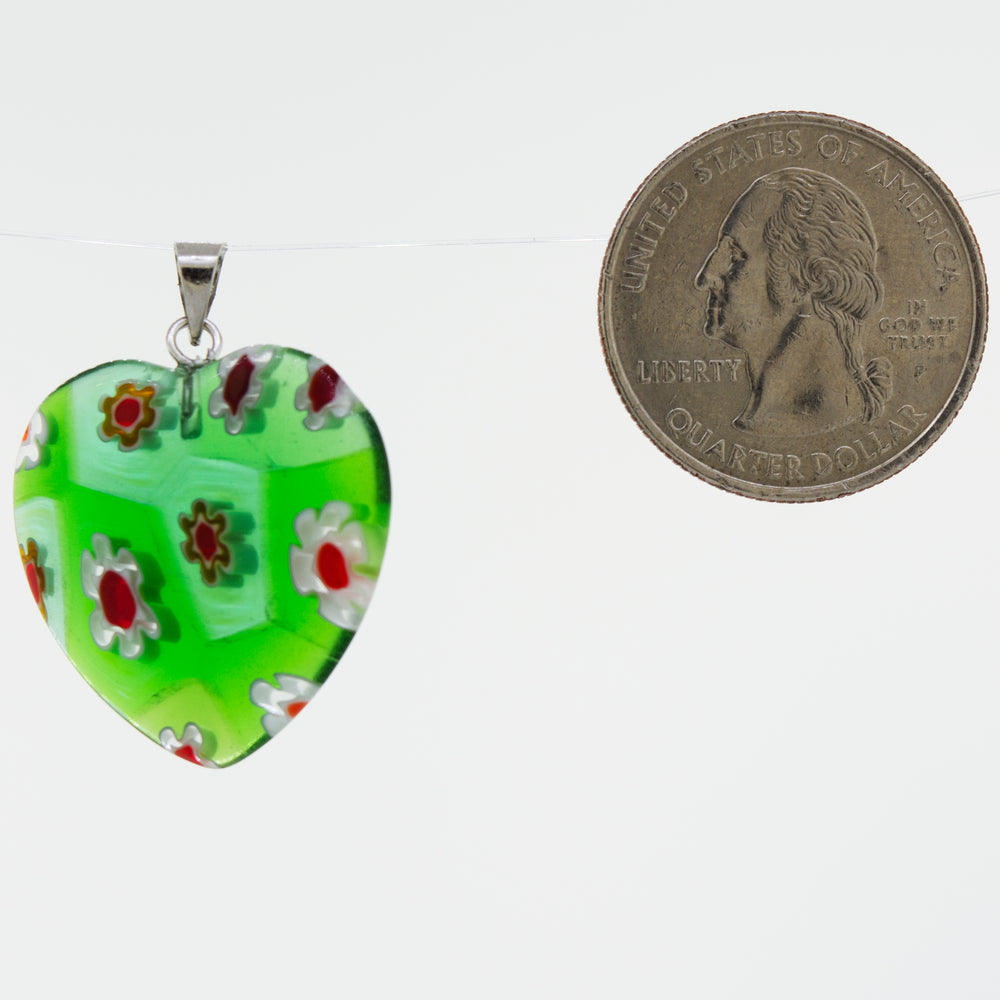A green, translucent resin heart pendant with a Super Silver Heart Pendant with Flower Pattern embedded.