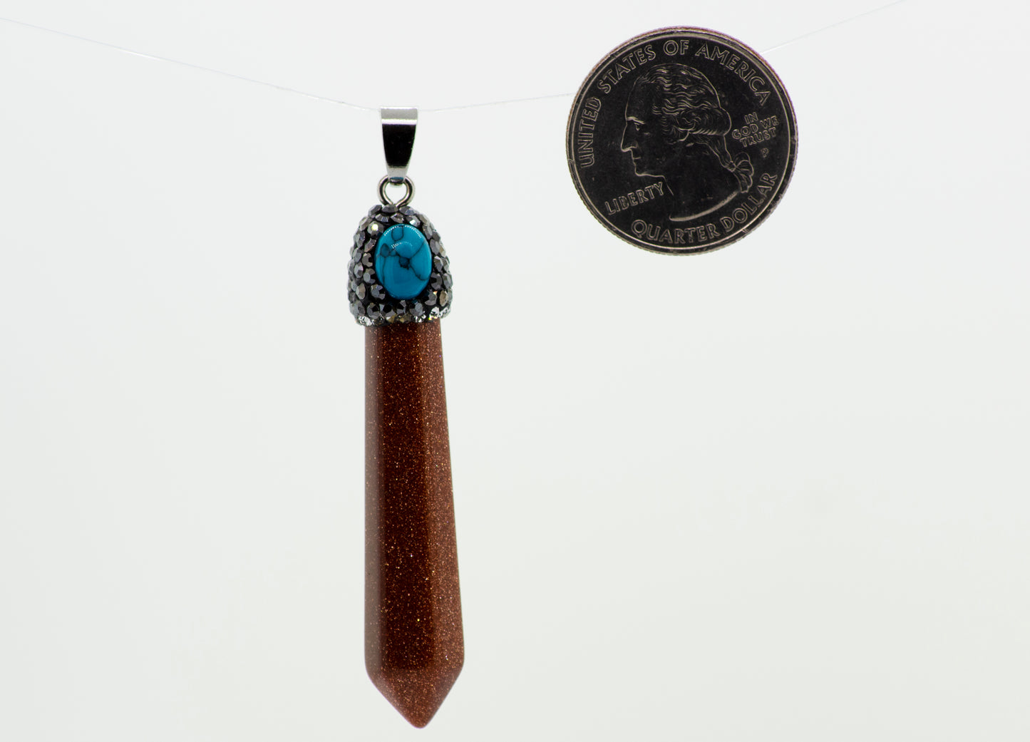 
                  
                    A Super Silver Stone Obelisk Pendant with a turquoise stone and an obelisk-shaped crystal next to it.
                  
                