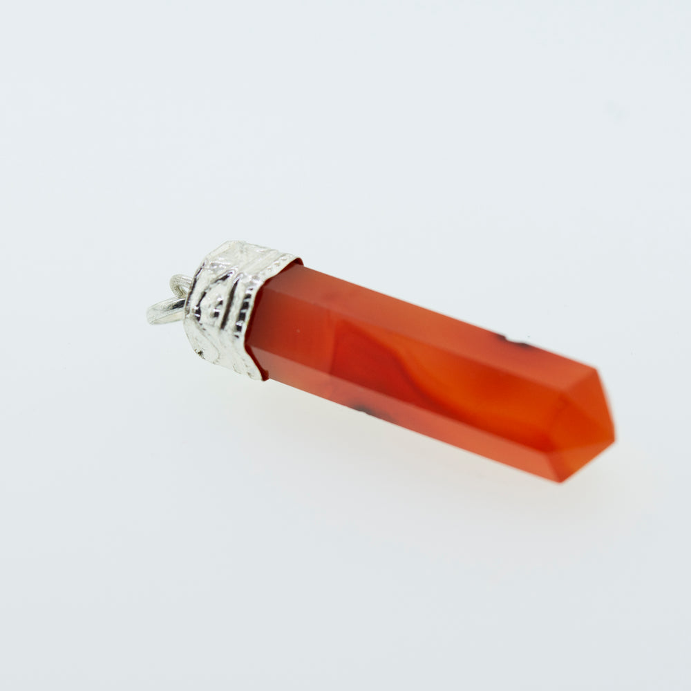 
                  
                    A Raw Stone Obelisk Pendant made of orange jade, perfect for layering with a Super Silver sterling silver chain.
                  
                