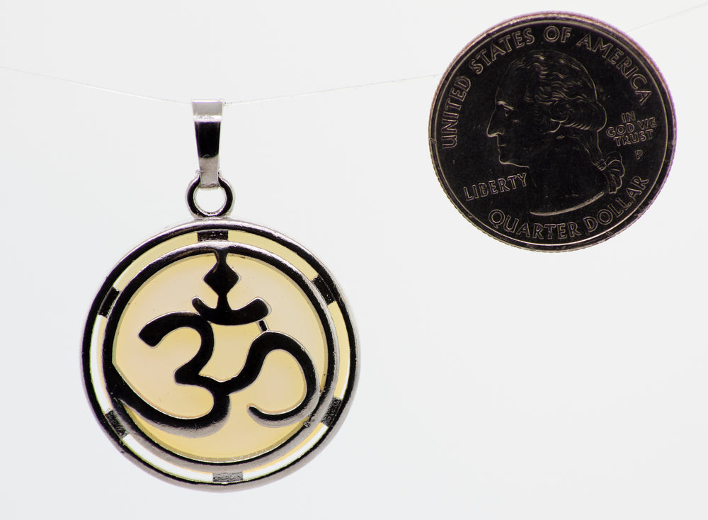 
                  
                    A round stone Super Silver Om Pendant plated with a coin next to it.
                  
                