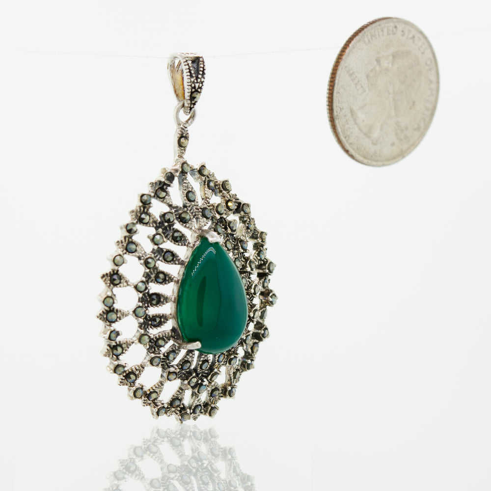 A Beautiful Aventurine Pendant from Super Silver next to a dime.