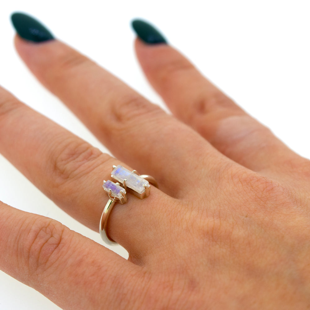 
                  
                    A woman's hand holding a Super Silver Online Only Exclusive Adjustable Moonstone Ring with two opal stones.
                  
                