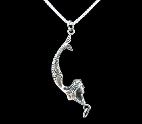 
                  
                    A Super Silver Lounging Mermaid Pendant necklace hanging from a chain on a black background.
                  
                