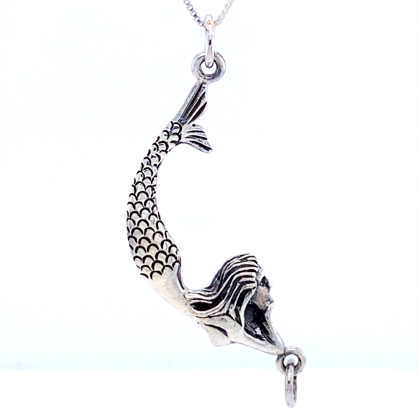 A Super Silver Lounging Mermaid Pendant necklace, inspired by the sea goddess, hanging gracefully from a chain.
