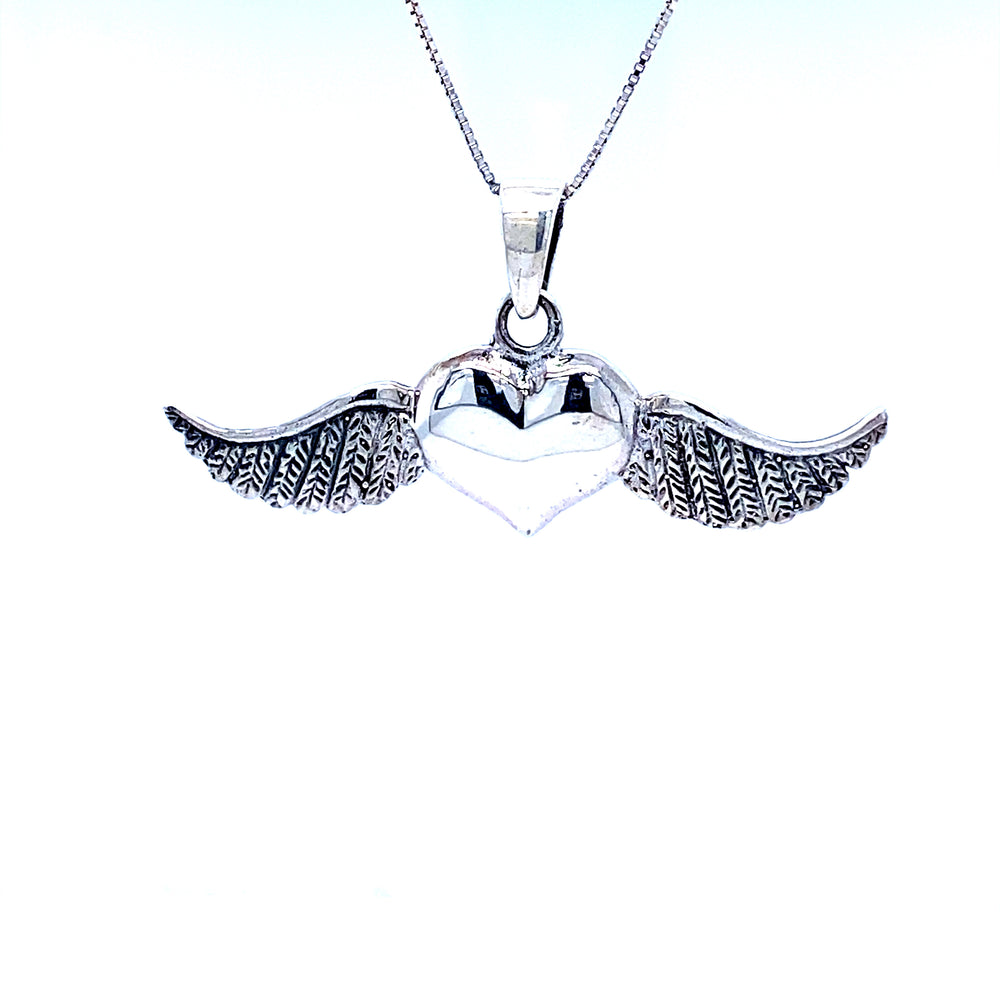 A Super Silver Heart With Wings Pendant with an oxidized finish, suspended on a chain.