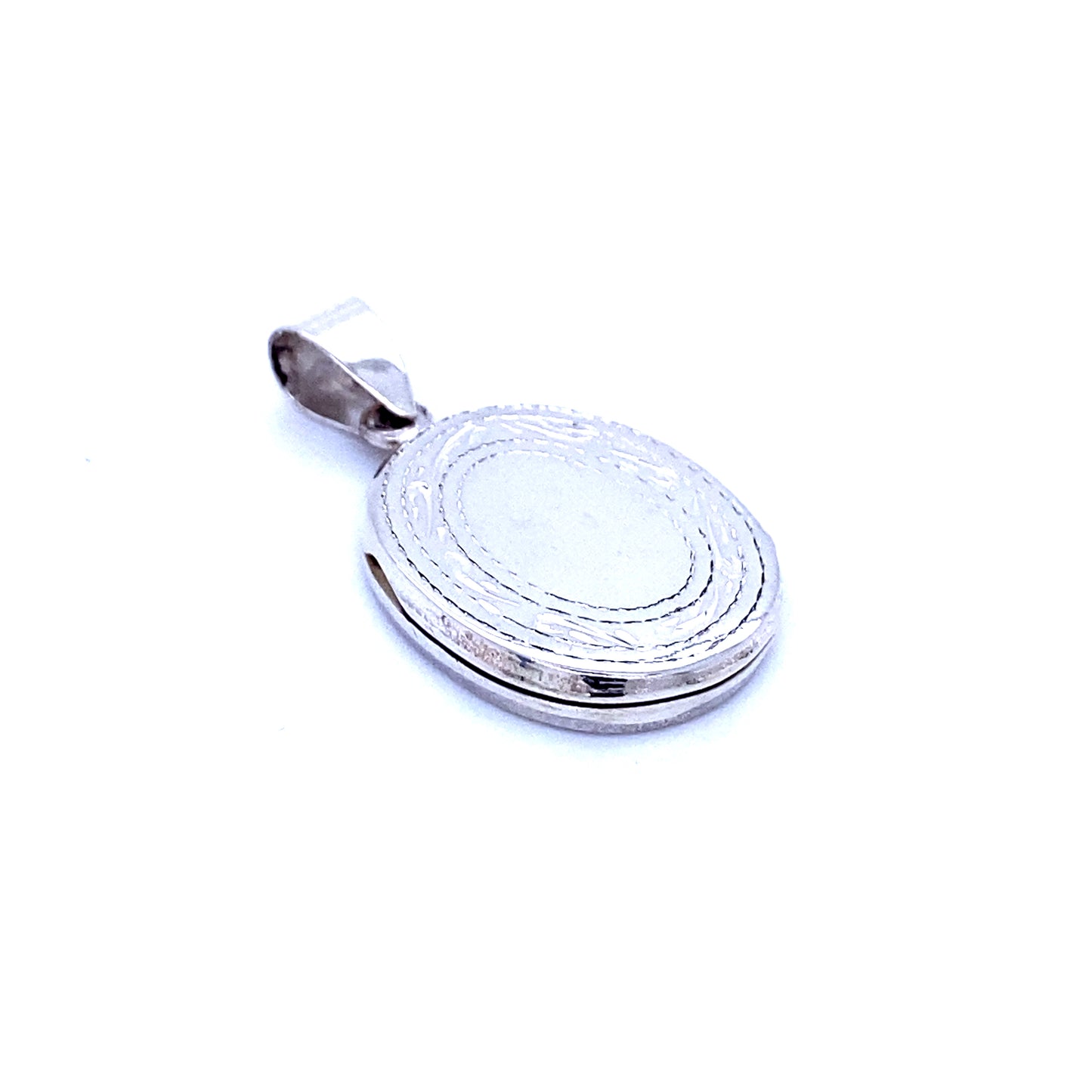 A Victorian era silver oval locket pendant with an etched border on a white background.