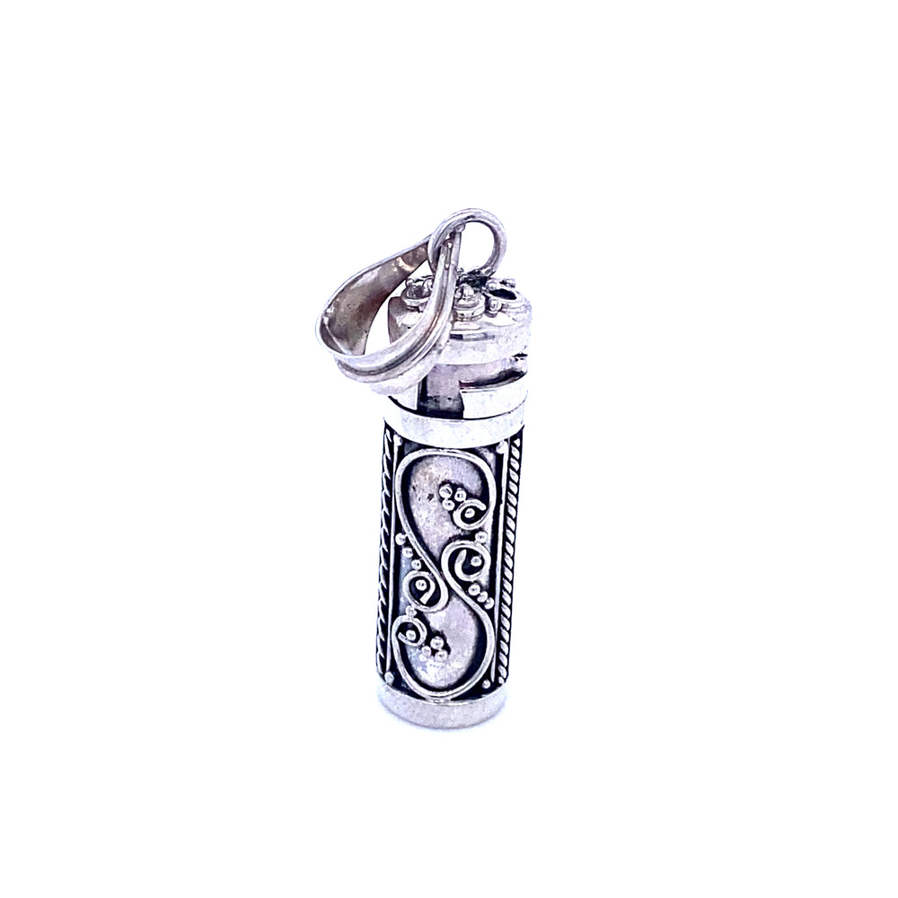 
                  
                    A silver lighter with an ornate design featuring Super Silver prayer box pendants.
                  
                