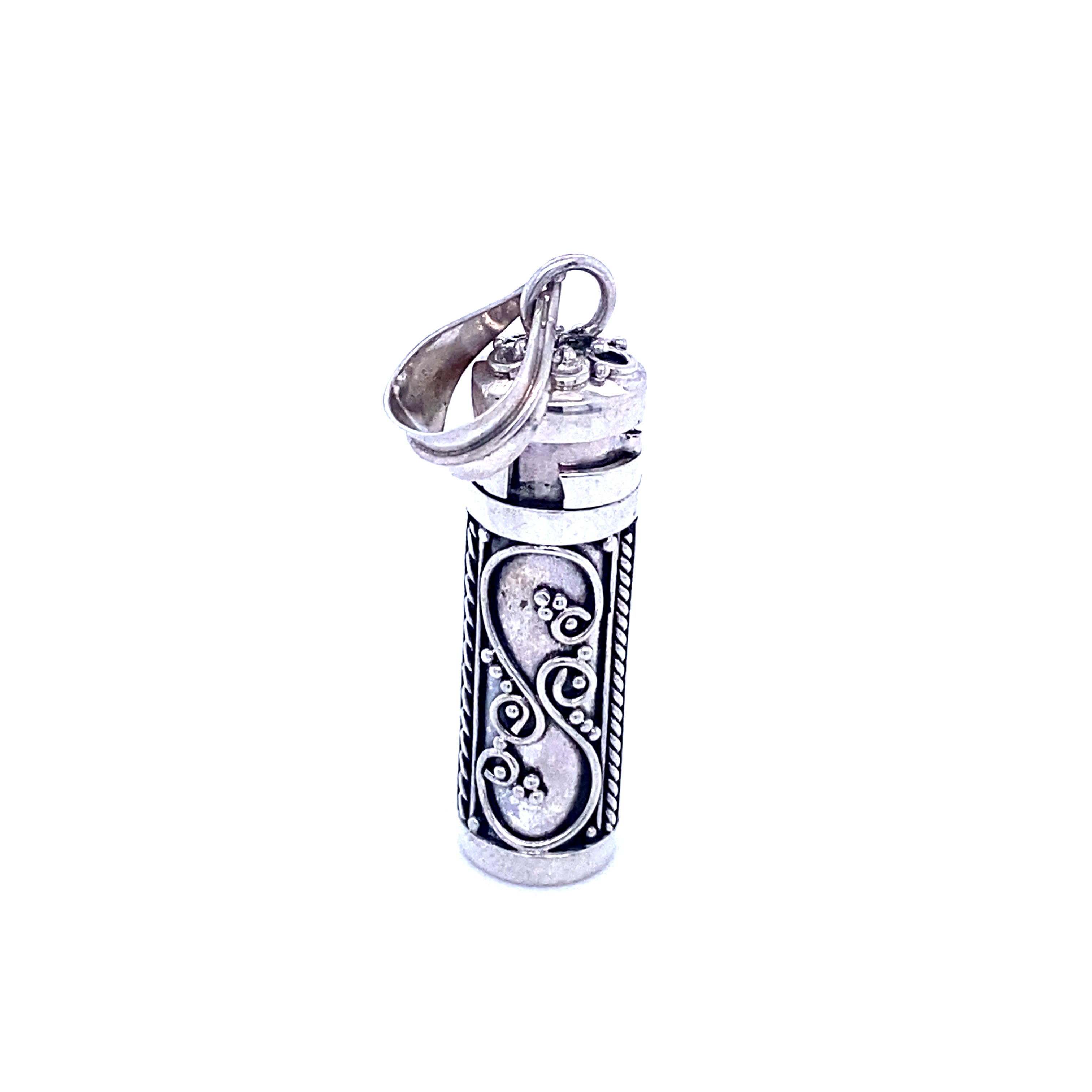 A silver lighter with an ornate design featuring Super Silver prayer box pendants.