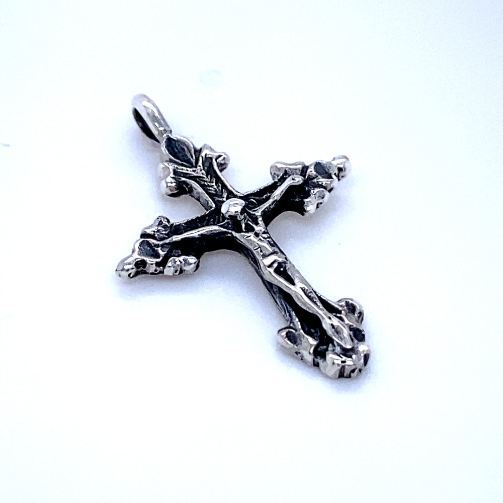 An ornate Super Silver Crucifix Charm pendant with vintage appeal on a white surface.