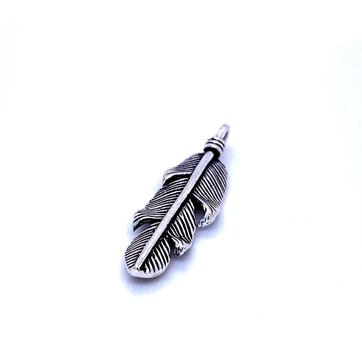 A Super Silver rustic design silver feather pendant on a white background.