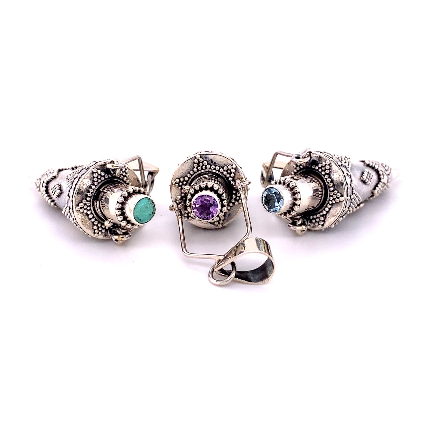 
                  
                    Three Super Silver Ornate Stone Poison Pendants with turquoise and amethyst gemstone stones.
                  
                