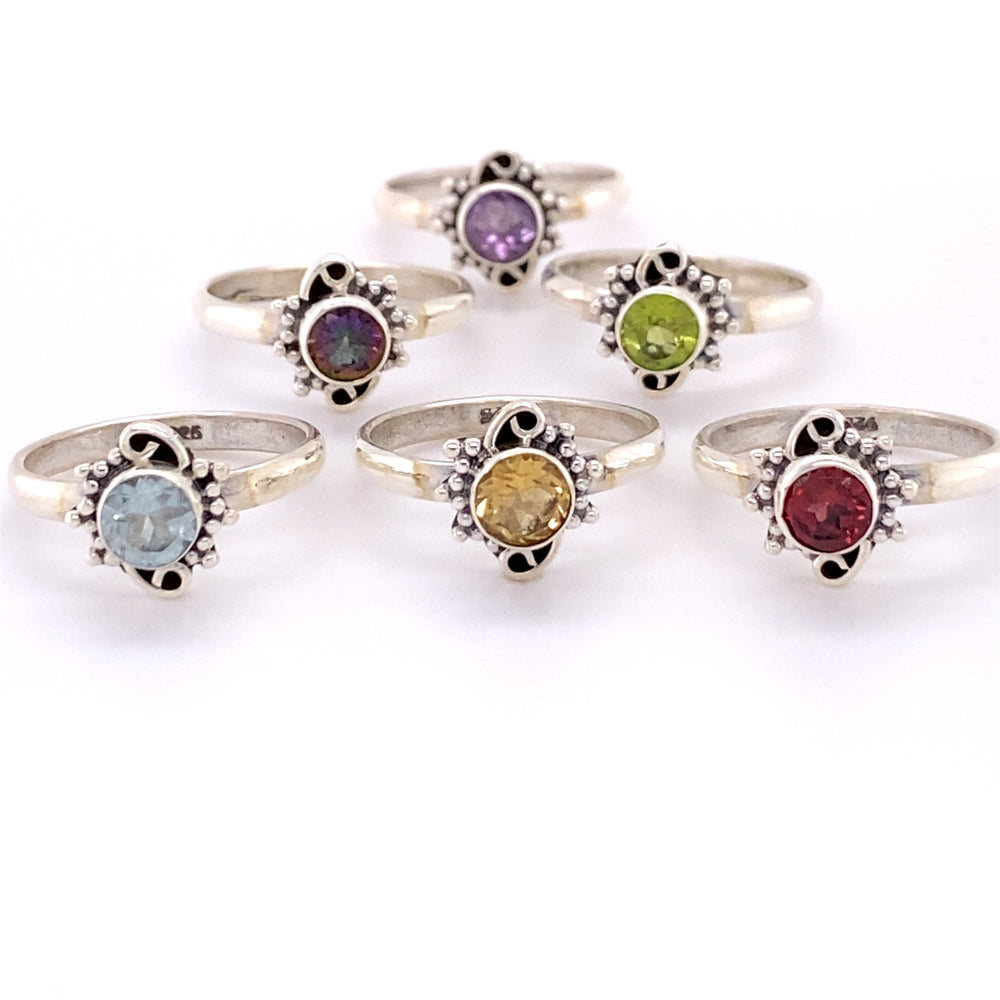 A collection of Small Round Gemstone Rings with Bead and Swirl Border, adorned with cabochon stones in various vibrant colors.