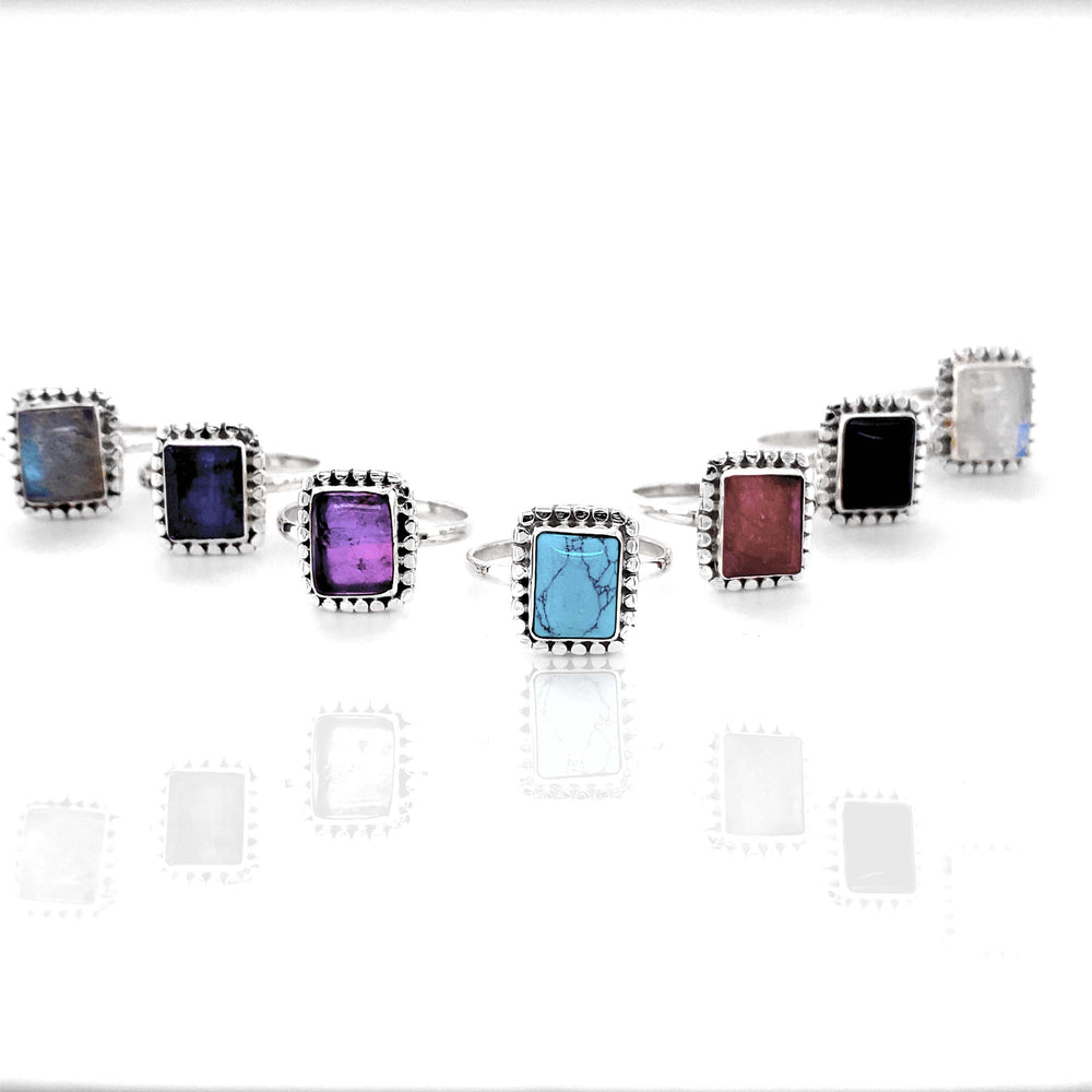 
                  
                    A group of Square Rings with Natural Gemstones on a white background.
                  
                