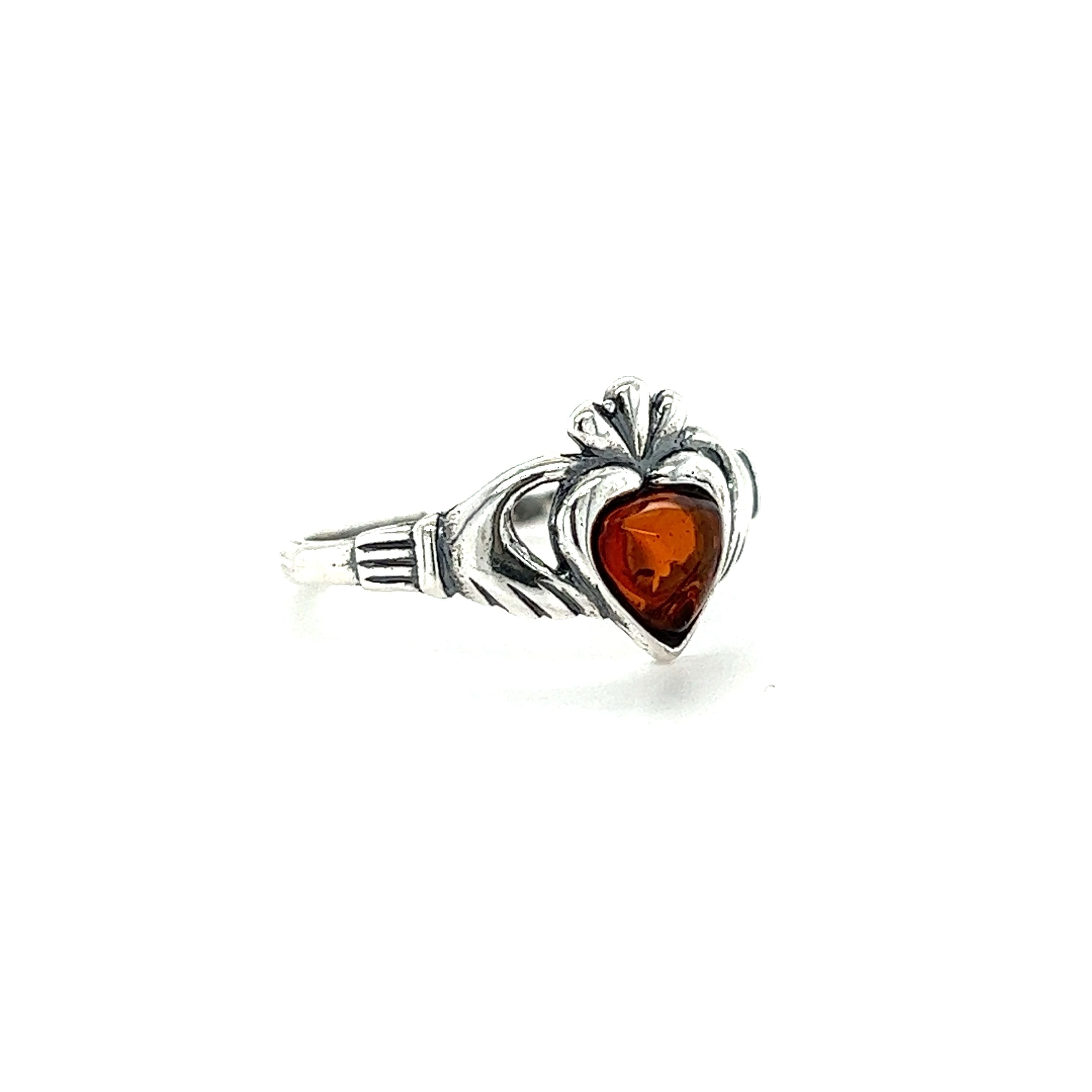 A Claddagh Amber Heart Ring crafted from .925 Sterling Silver, symbolizing both love and friendship.