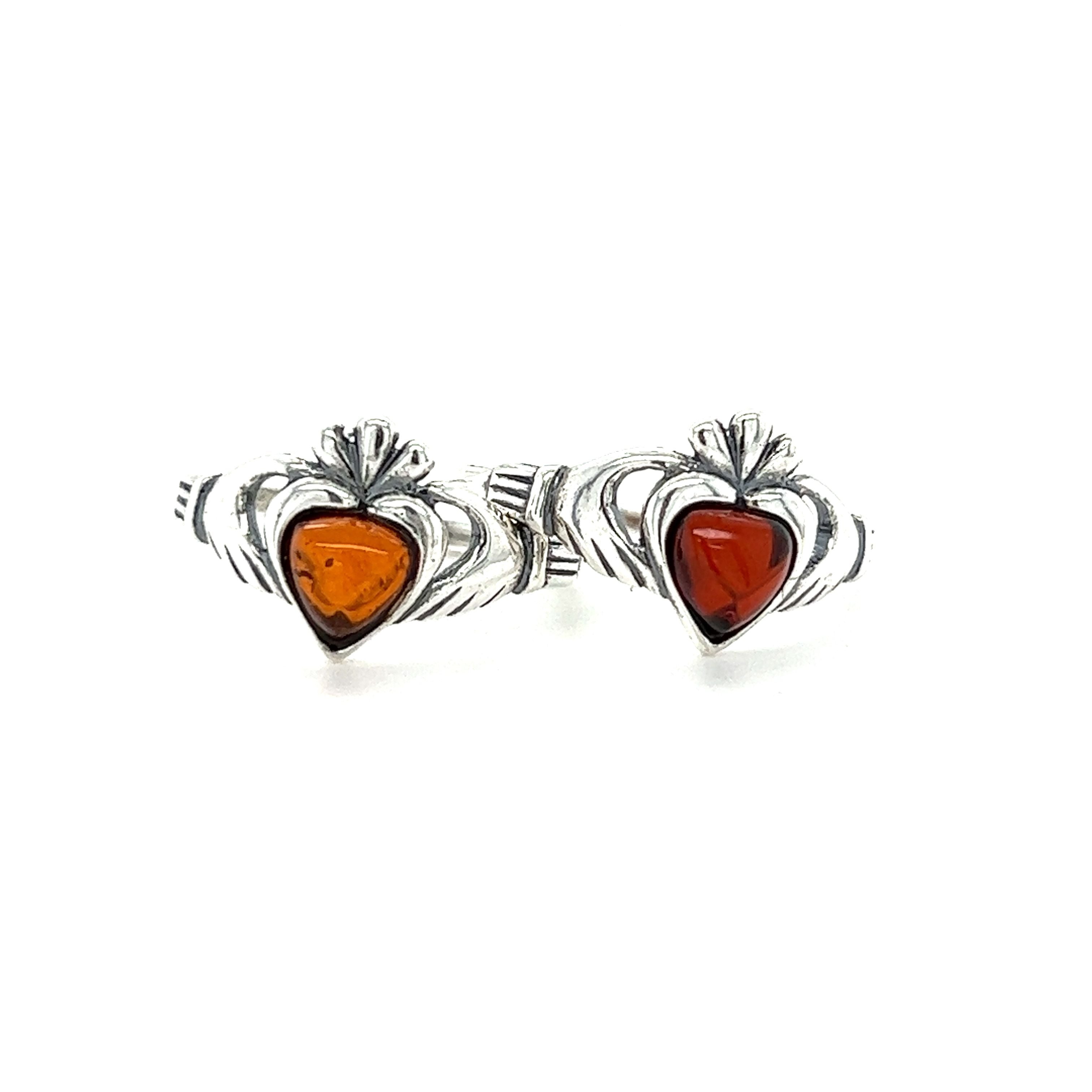 A pair of Claddagh Amber Heart Rings with amber and sterling silver. These love and friendship rings feature Claddagh Baltic amber accents on a beautiful .925 Sterling Silver band from the Super Silver brand.