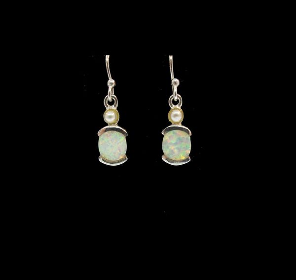 A pair of Super Silver White Created Opal Oblong Earrings with white created opal on a black background.