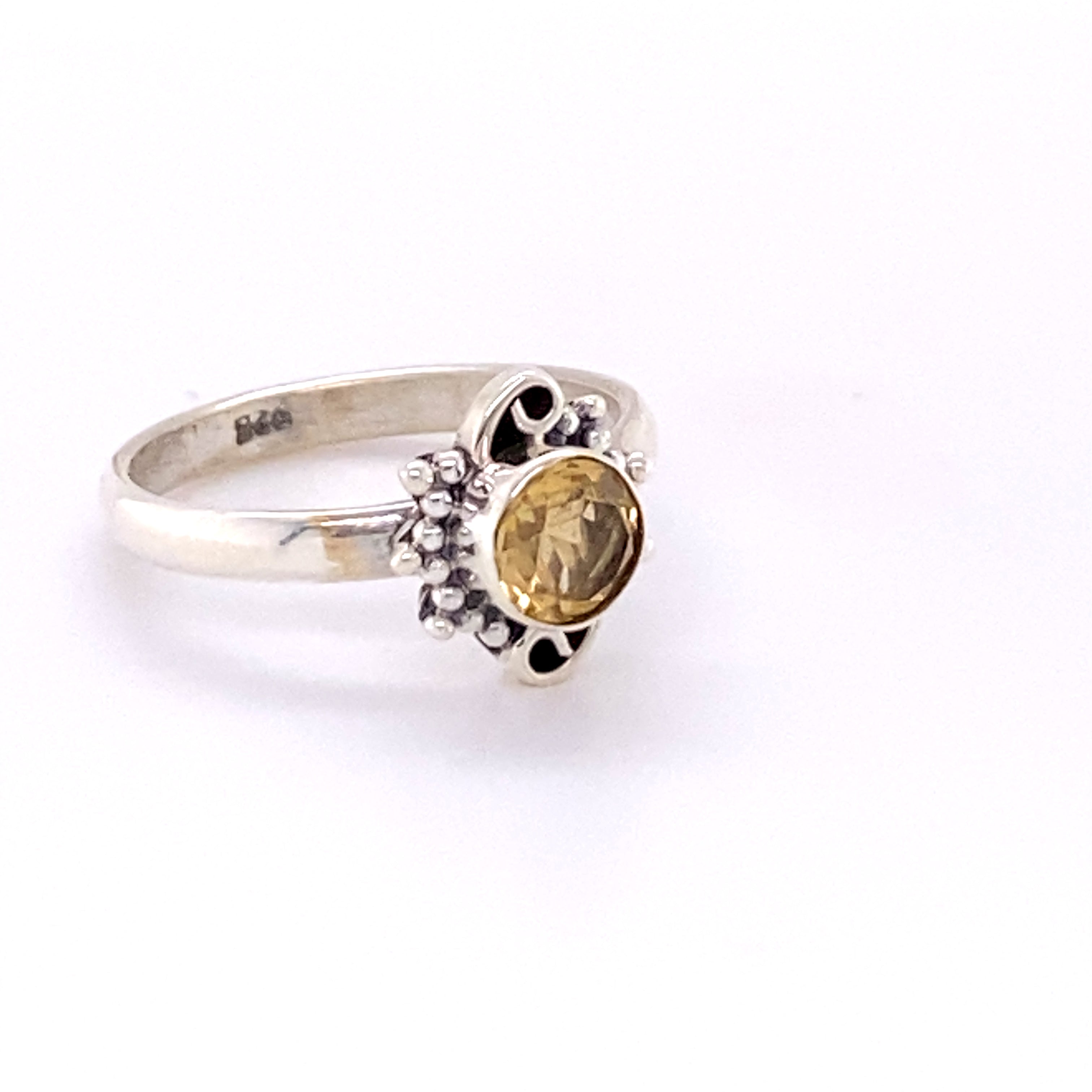A cabochon cut Small Round Gemstone Ring with Bead and Swirl Border set in a sterling silver ring.