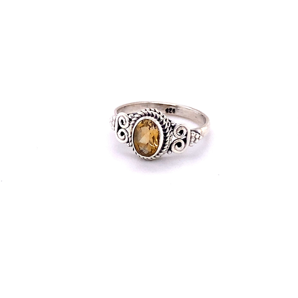 
                  
                    An Oval Faceted Gemstone Ring with a Swirl Design with a citrine stone.
                  
                