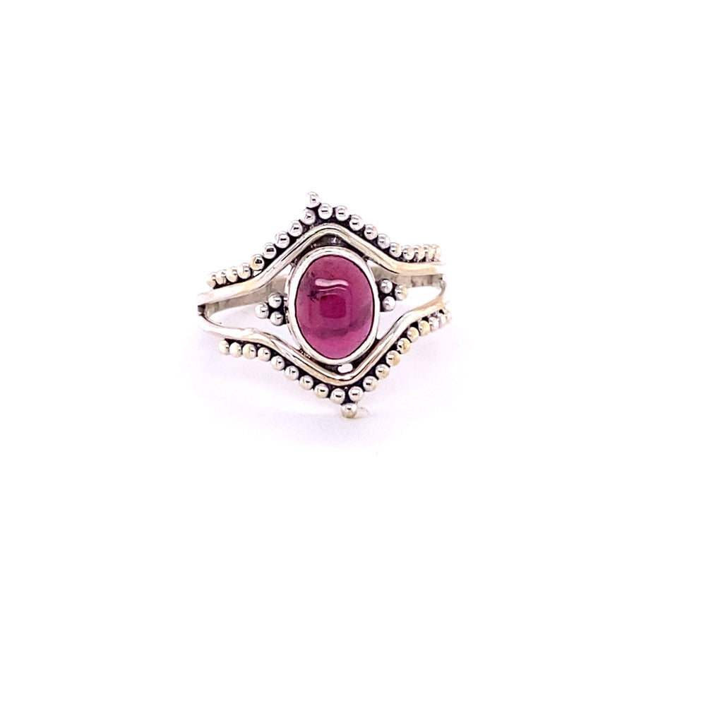 
                  
                    A Double Chevron Gemstone Ring with Ball Design with a ruby cabochon stone in the center.
                  
                