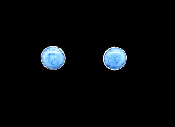 A pair of Super Silver Round Flat Denim Lapis Stud Earrings on a black background.