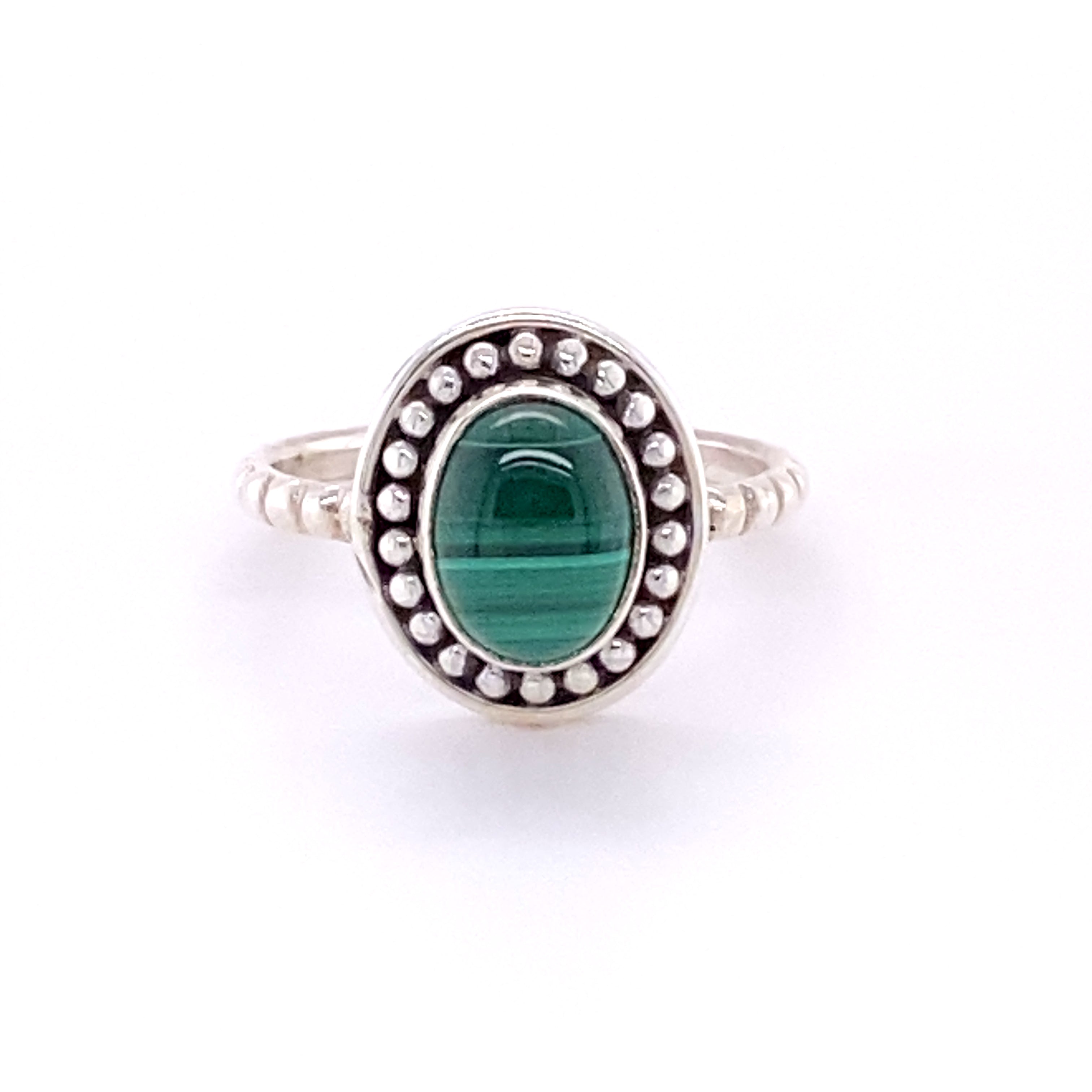 An oval gemstone ring with a silver ball border.
