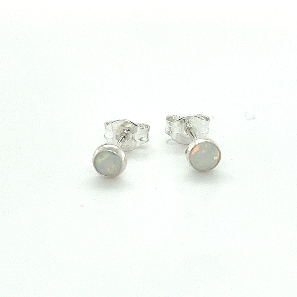 
                  
                    A pair of Dainty Opal Studs by Super Silver with minimalist designs on a white surface.
                  
                