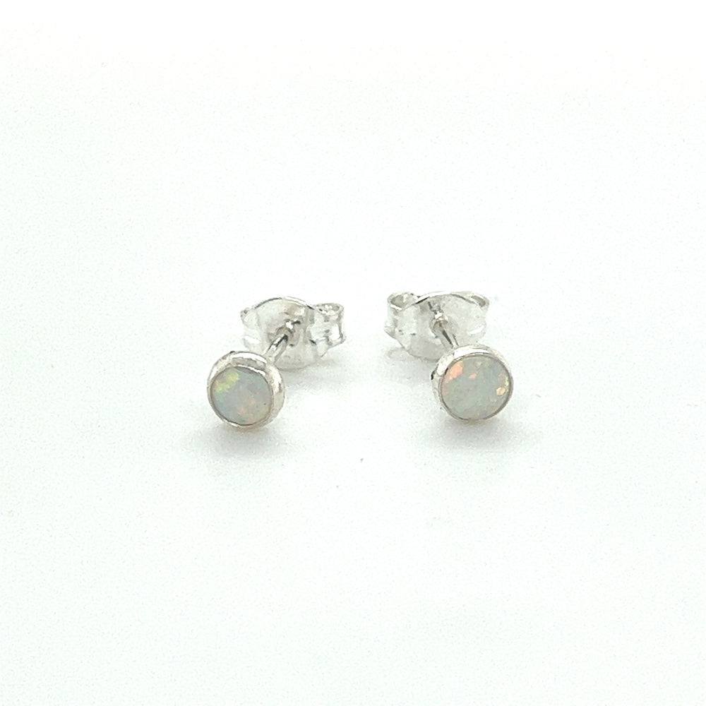 
                  
                    A pair of Dainty Opal Studs from Super Silver with minimalist designs on a white surface.
                  
                