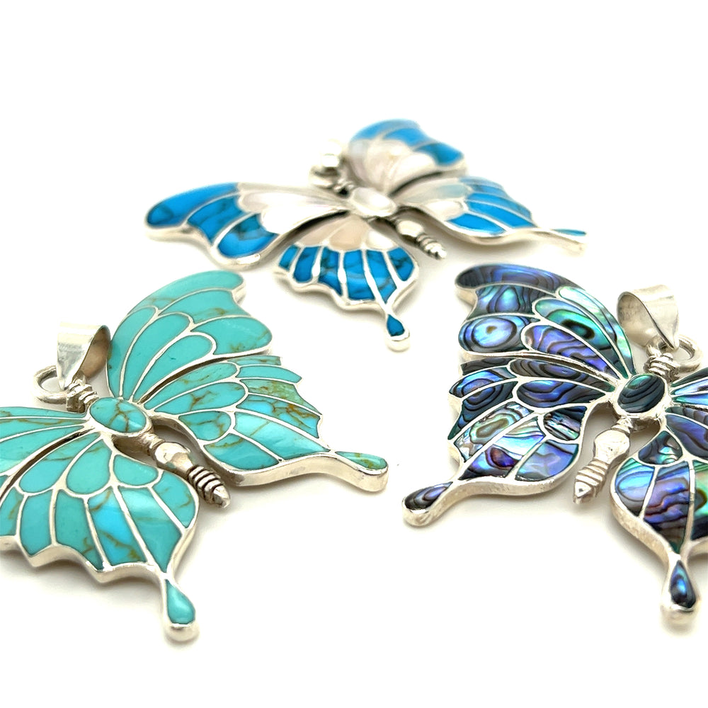 
                  
                    Three Stunning Inlay Butterfly Pendants by Super Silver on a white surface.
                  
                