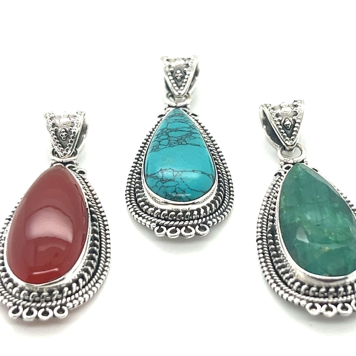 
                  
                    Three Super Silver Striking Teardrop Gemstone Pendants with Beaded Detailing, featuring turquoise and red stones.
                  
                