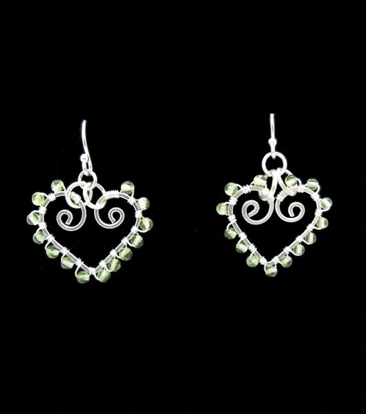 A pair of Super Silver Peridot Heart Shaped Dangle Earrings adorned with green Peridot beads.
