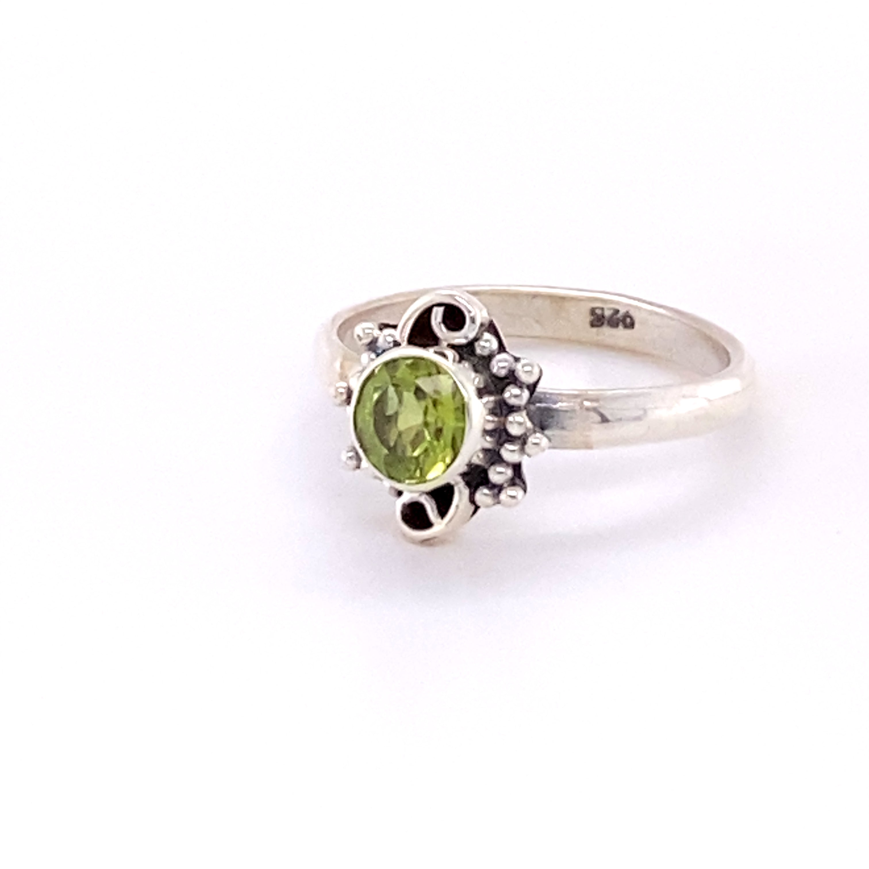A boho-inspired Small Round Gemstone Ring with Bead and Swirl Border adorned with a dazzling peridot gemstone.