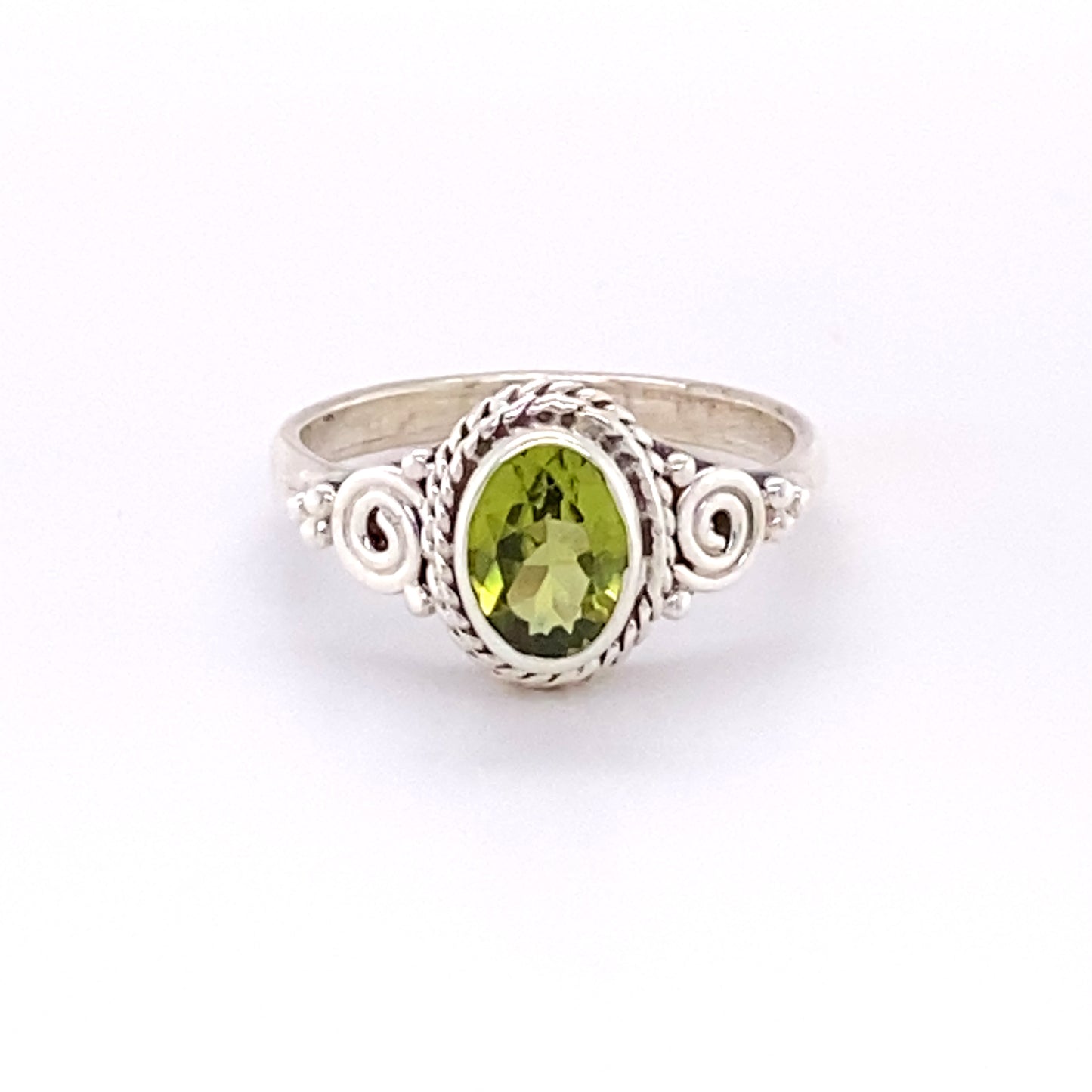 A Super Silver Oval Peridot Ring with Intricate Rope and Spiral Border.