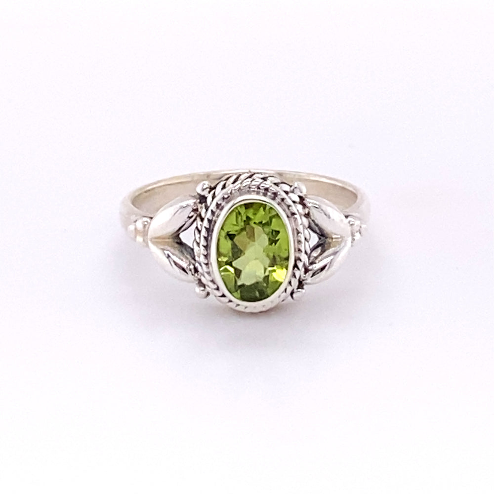 A Super Silver Oval Peridot Ring with Rope Border with a glowing center.