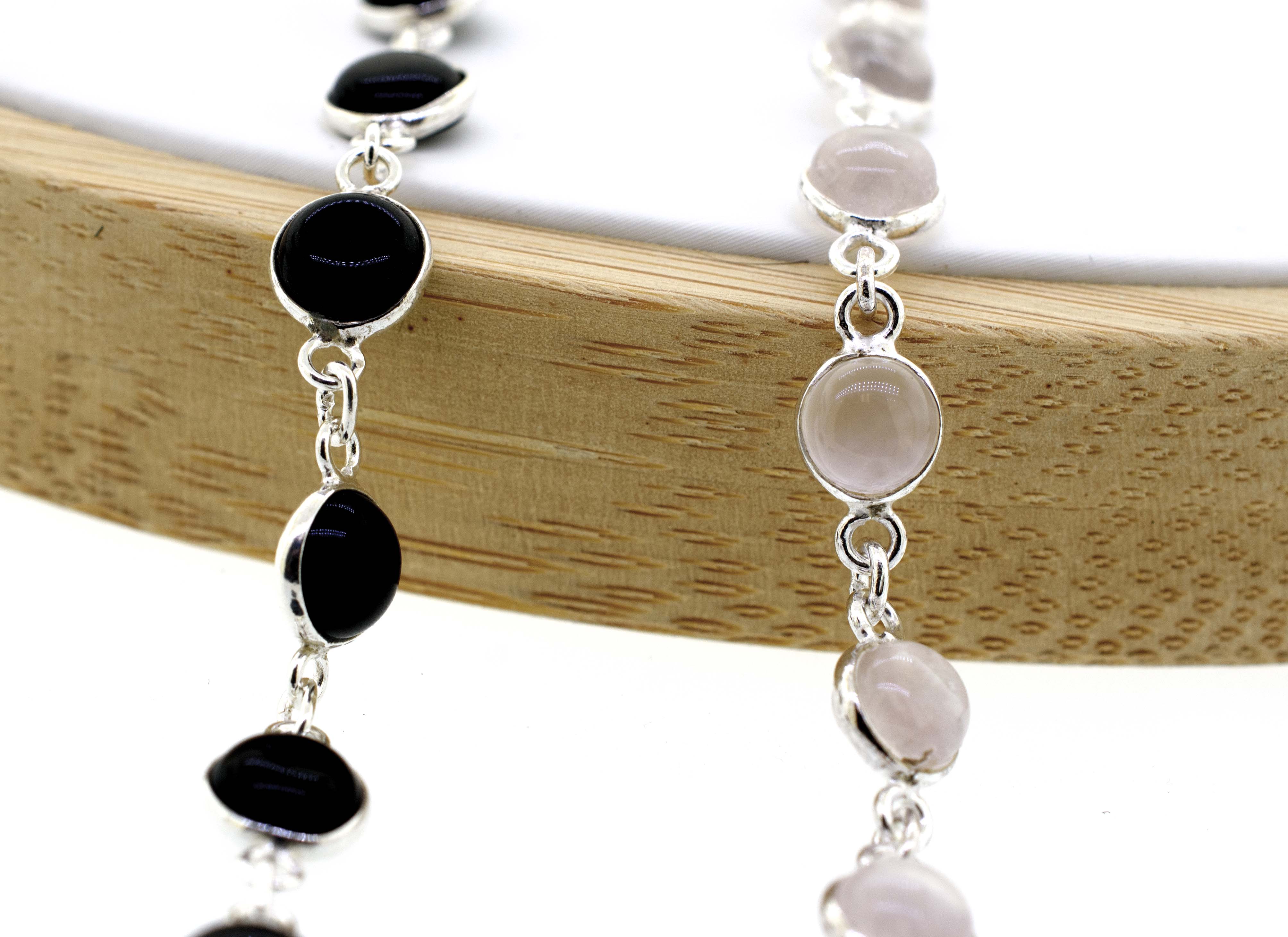 A delicate Super Silver bracelet adorned with round black and white gemstone stones, exuding an elegant touch of minimalism.