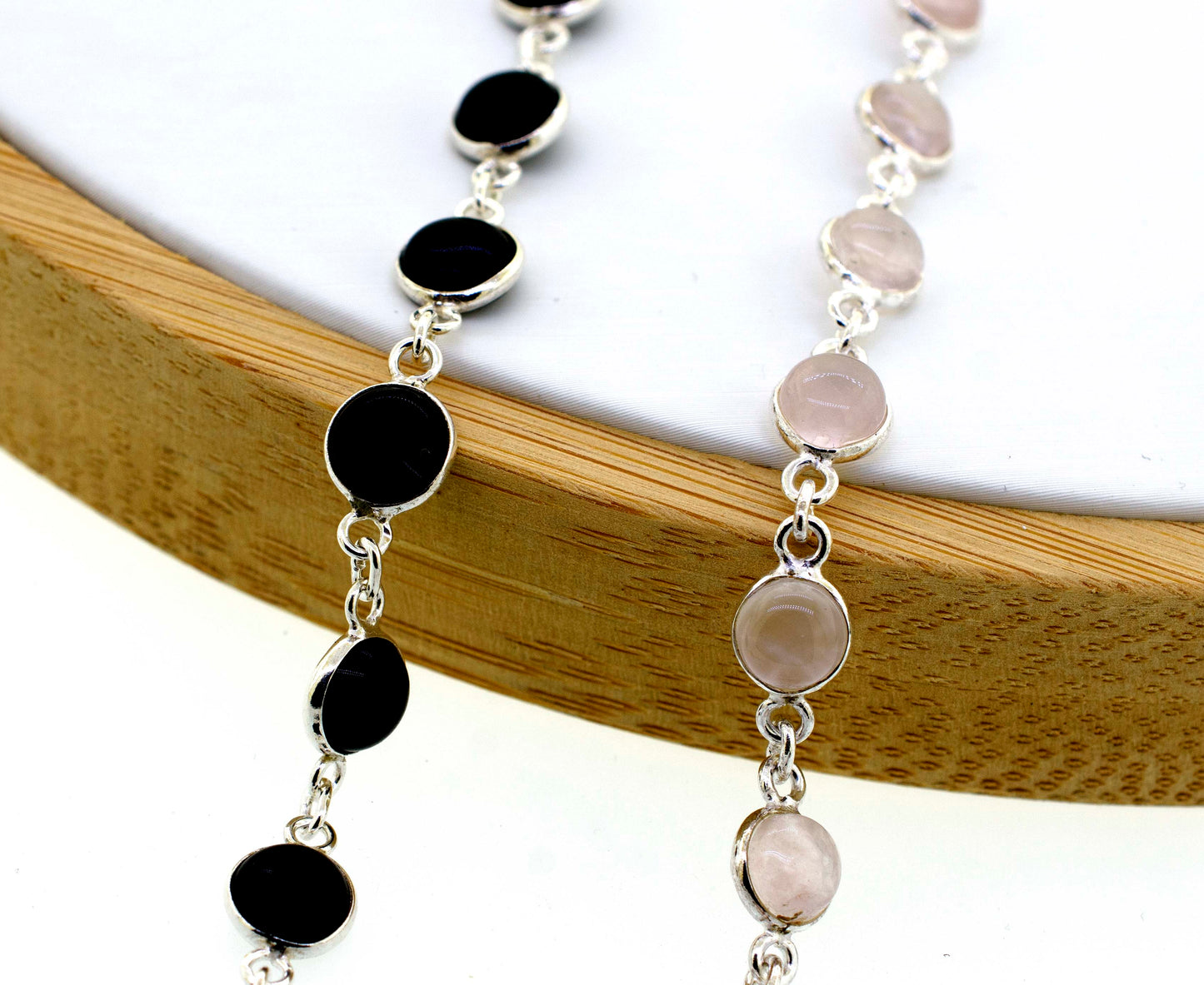 A delicate Super Silver necklace adorned with round black and pink Simple Round Gemstone Bracelet With Delicate Wire Setting stones, perfect for minimalism enthusiasts.