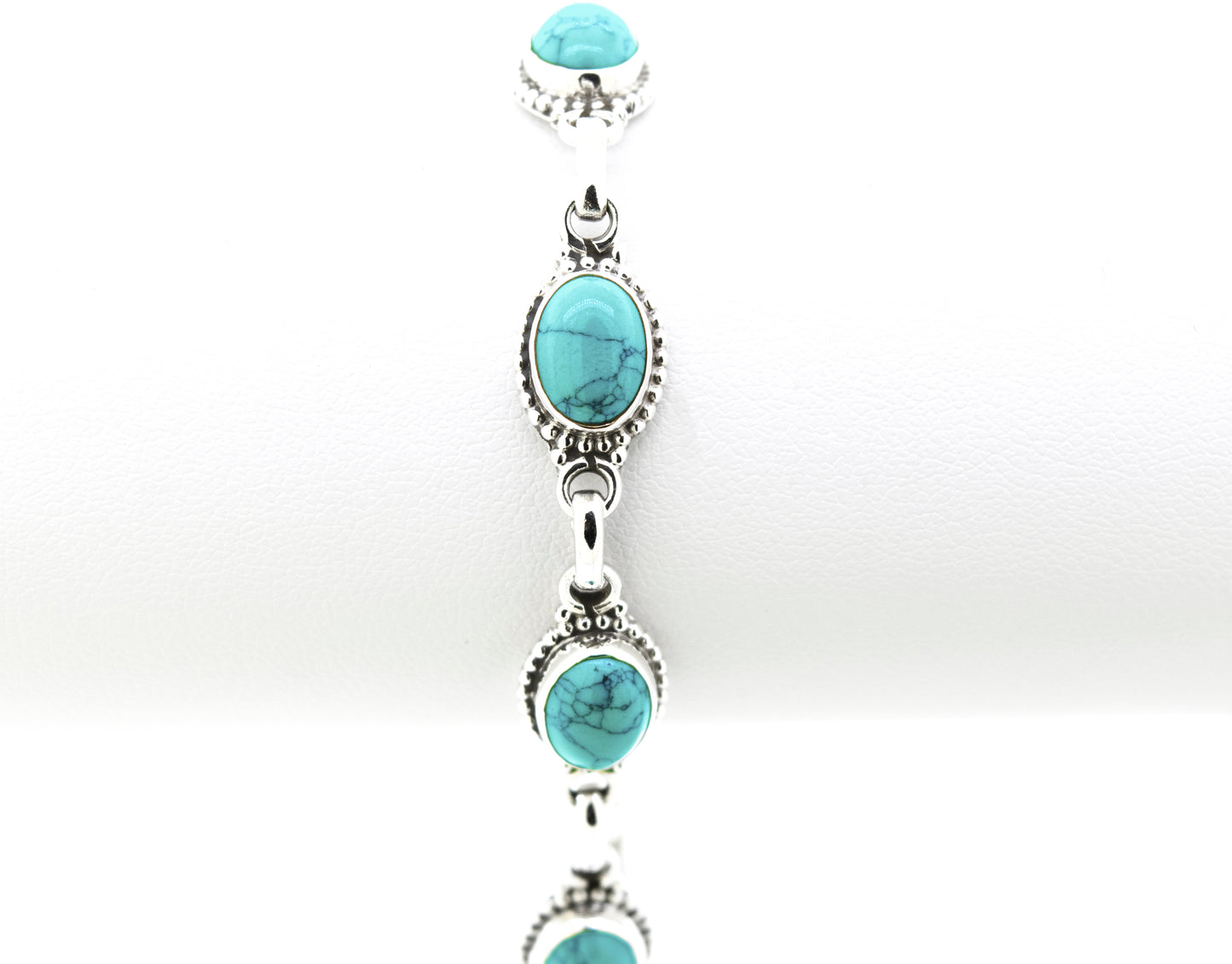 
                  
                    A Super Silver Oval Gemstone Bracelet with Half Ball Border adorned with turquoise gemstones.
                  
                