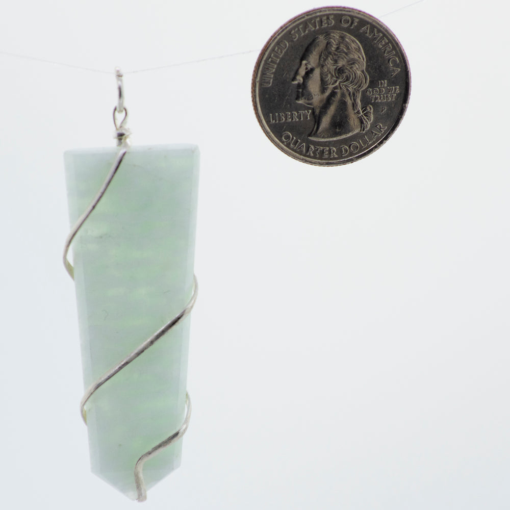 A green jade pendant hanging from a Super Silver silver chain, Super Silver wire wrapped stone slab pendant.