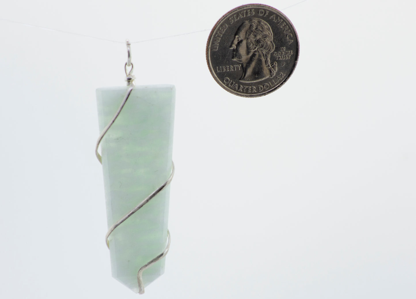 A green jade pendant hanging from a Super Silver silver chain, Super Silver wire wrapped stone slab pendant.