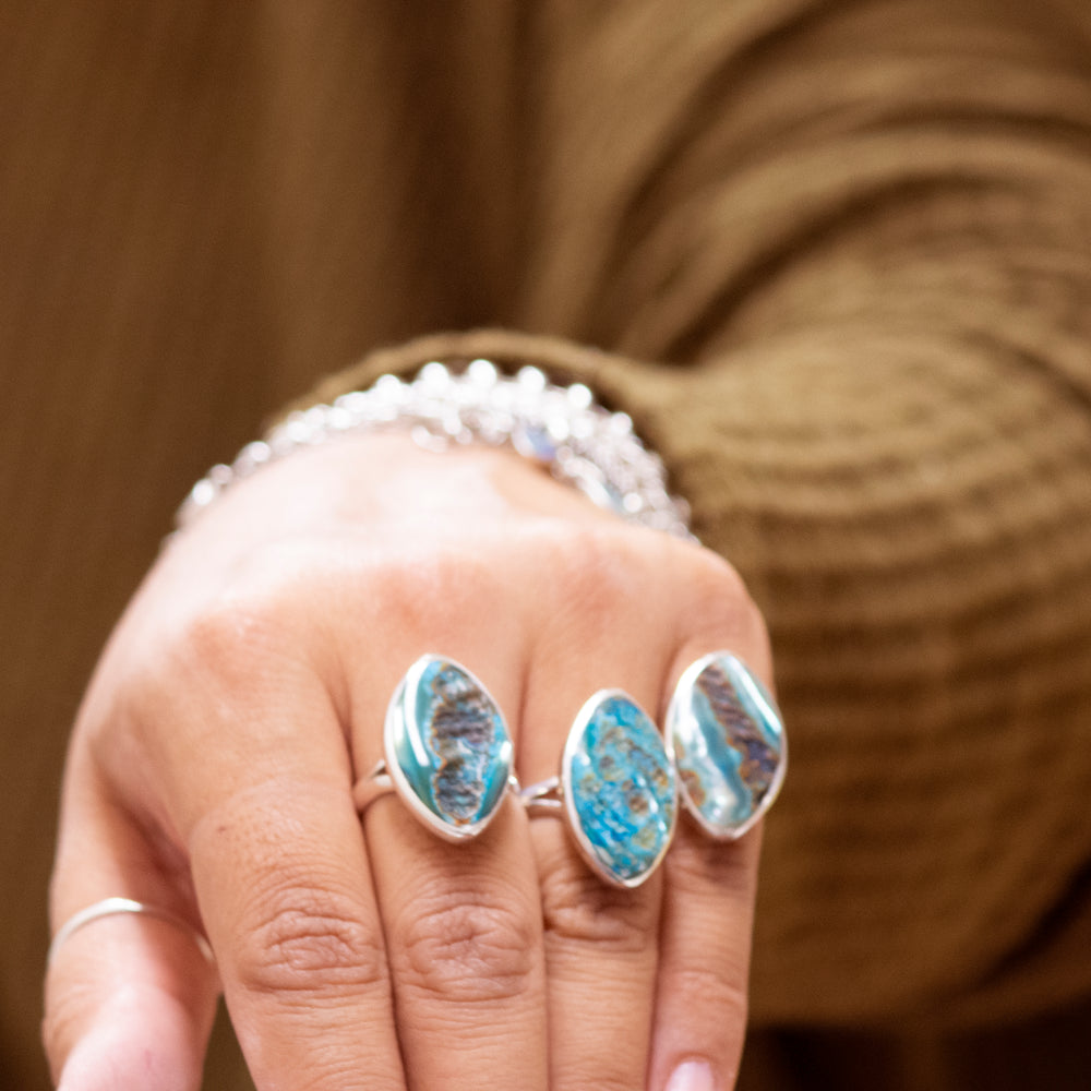 
                  
                    A woman's hand holding a Super Silver Dyed Natural Abalone Ring.
                  
                