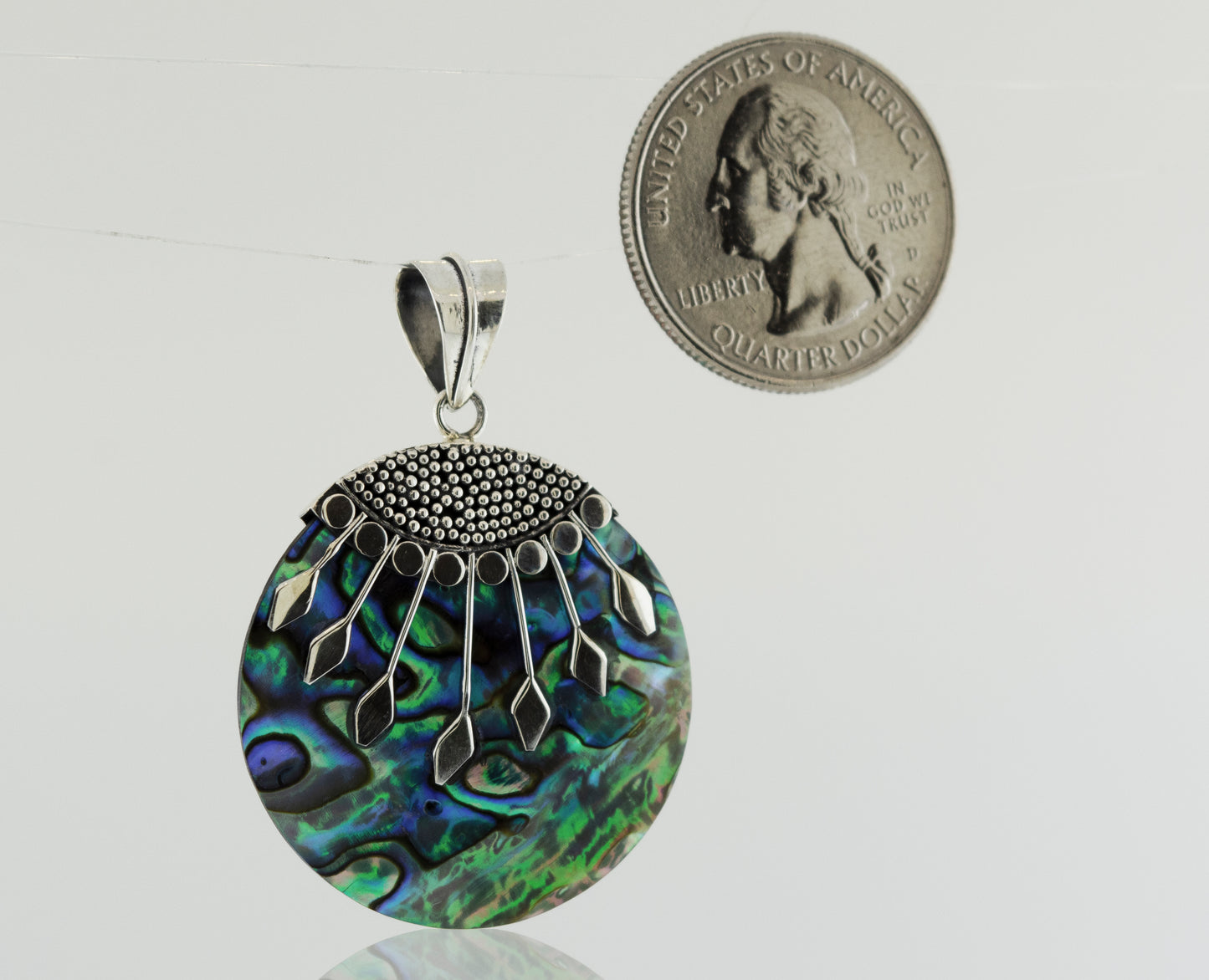 A Circle Abalone Pendant with intricate Bali detail, made of .925 Sterling Silver, showcased next to a dime for scale.