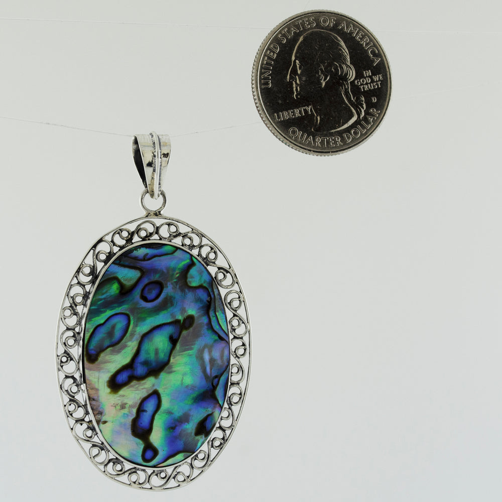 A statement piece pendant featuring an Oval Abalone Pendant with filigree border made by Super Silver.