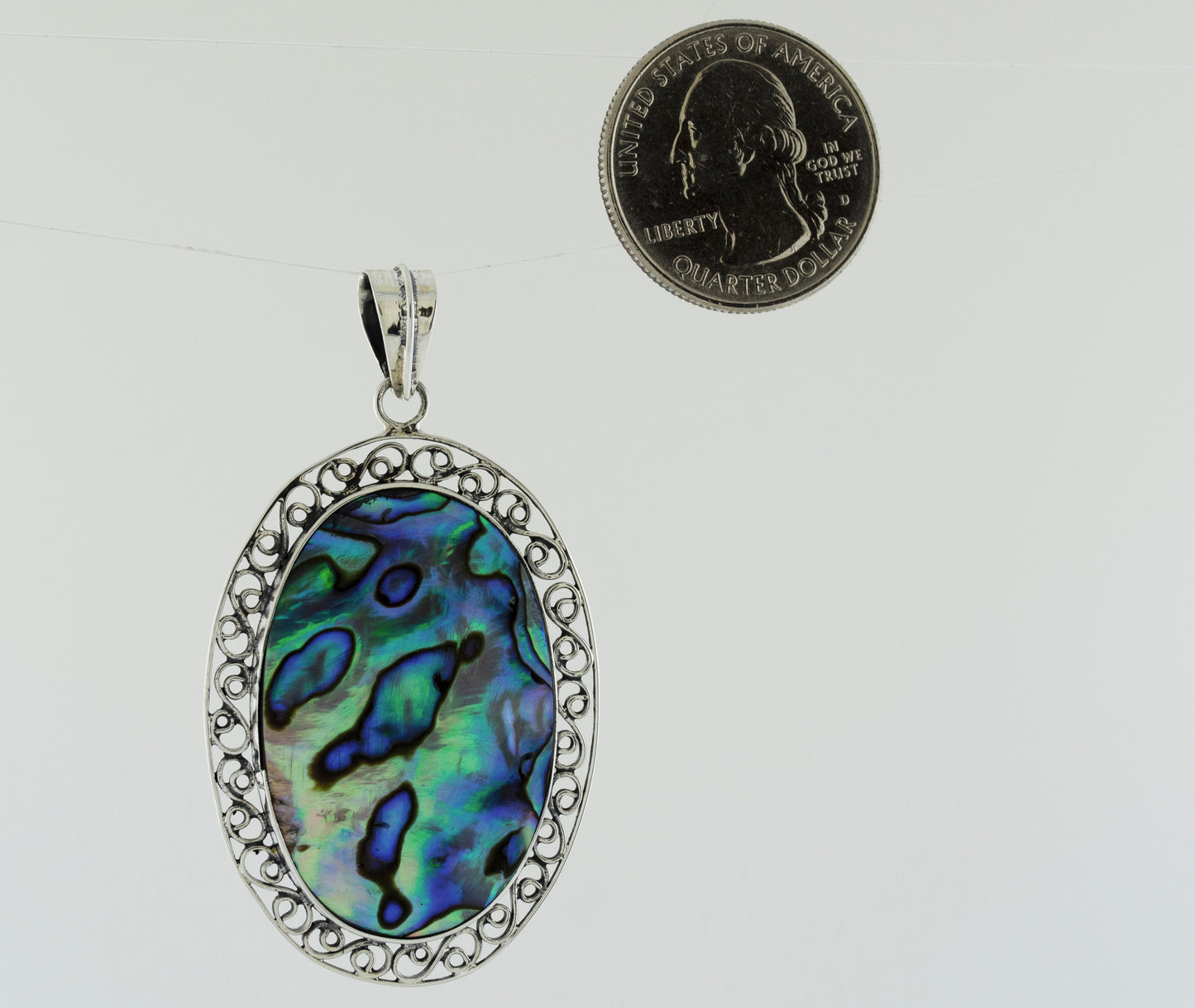 A statement piece pendant featuring an Oval Abalone Pendant with filigree border made by Super Silver.