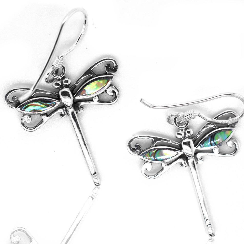 
                  
                    A pair of Super Silver Dragonfly Abalone Earrings on a white surface.
                  
                