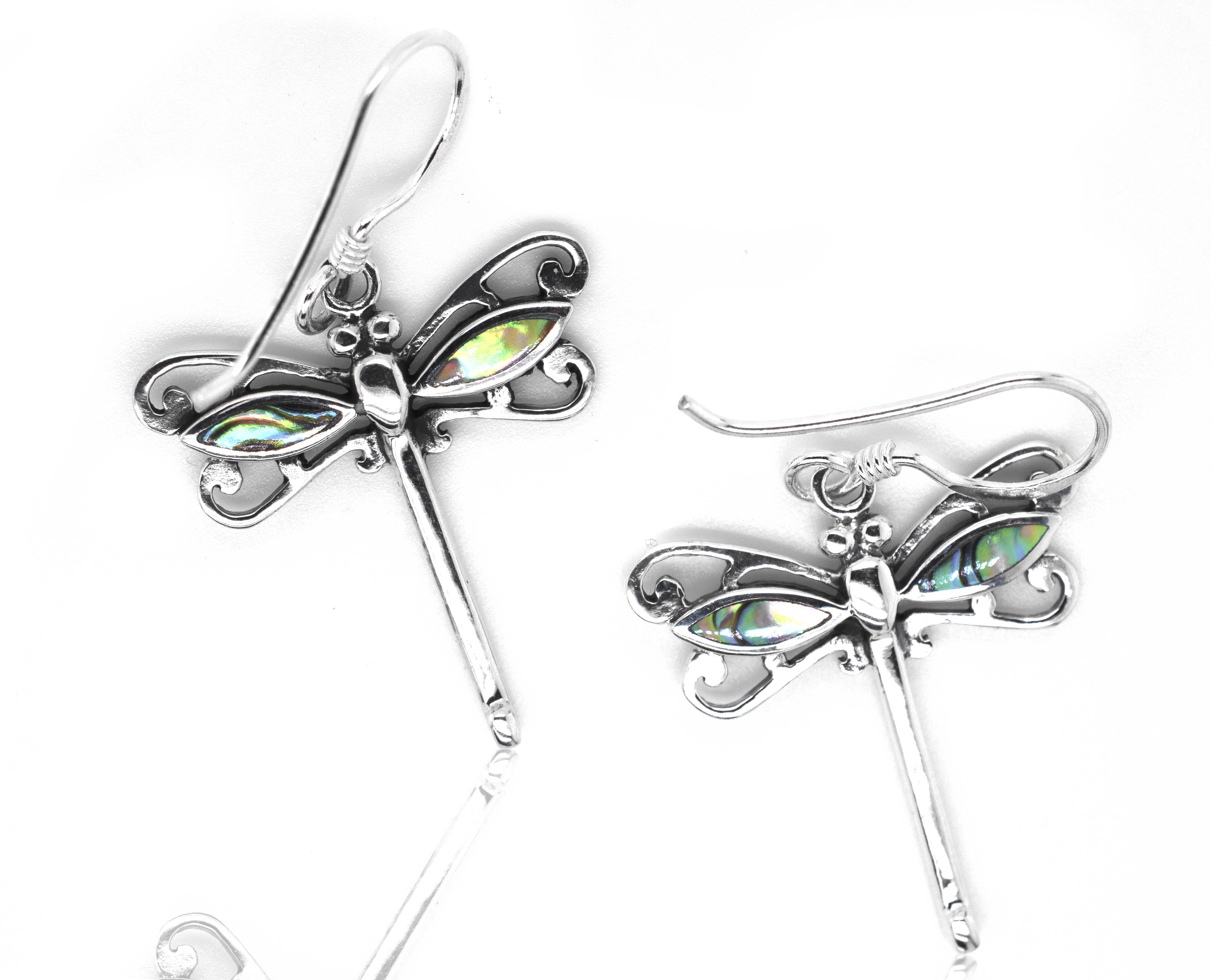 A pair of Super Silver Dragonfly Abalone Earrings on a white surface.