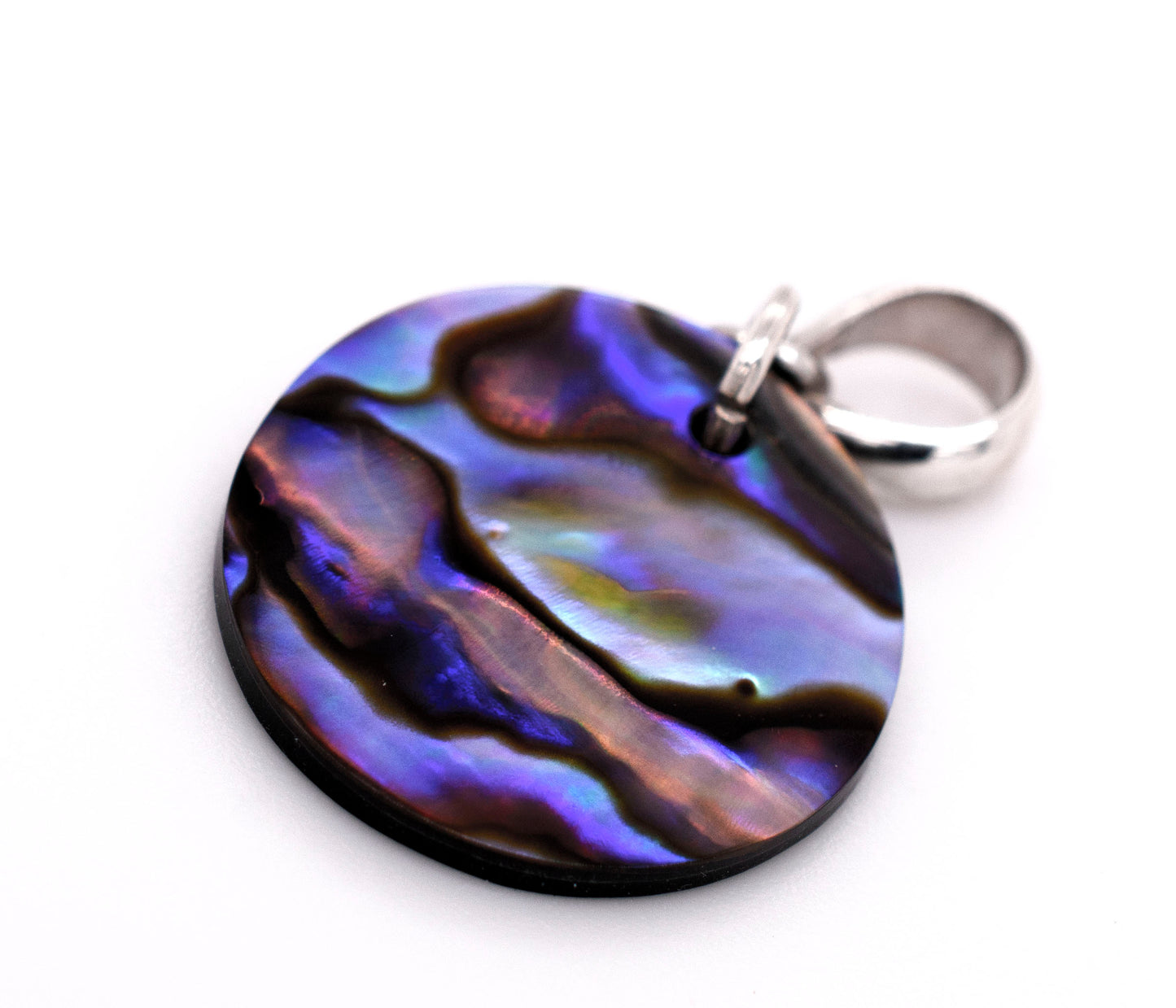 A Super Silver Charming Abalone Pendant displayed on a white surface, showcasing its exquisite beauty and healing properties.