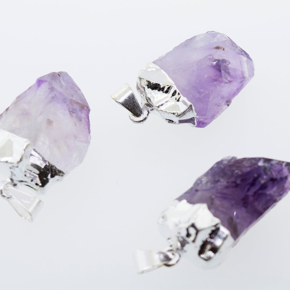 
                  
                    Three Natural Amethyst Crystal Pendants on a Super Silver plated surface.
                  
                